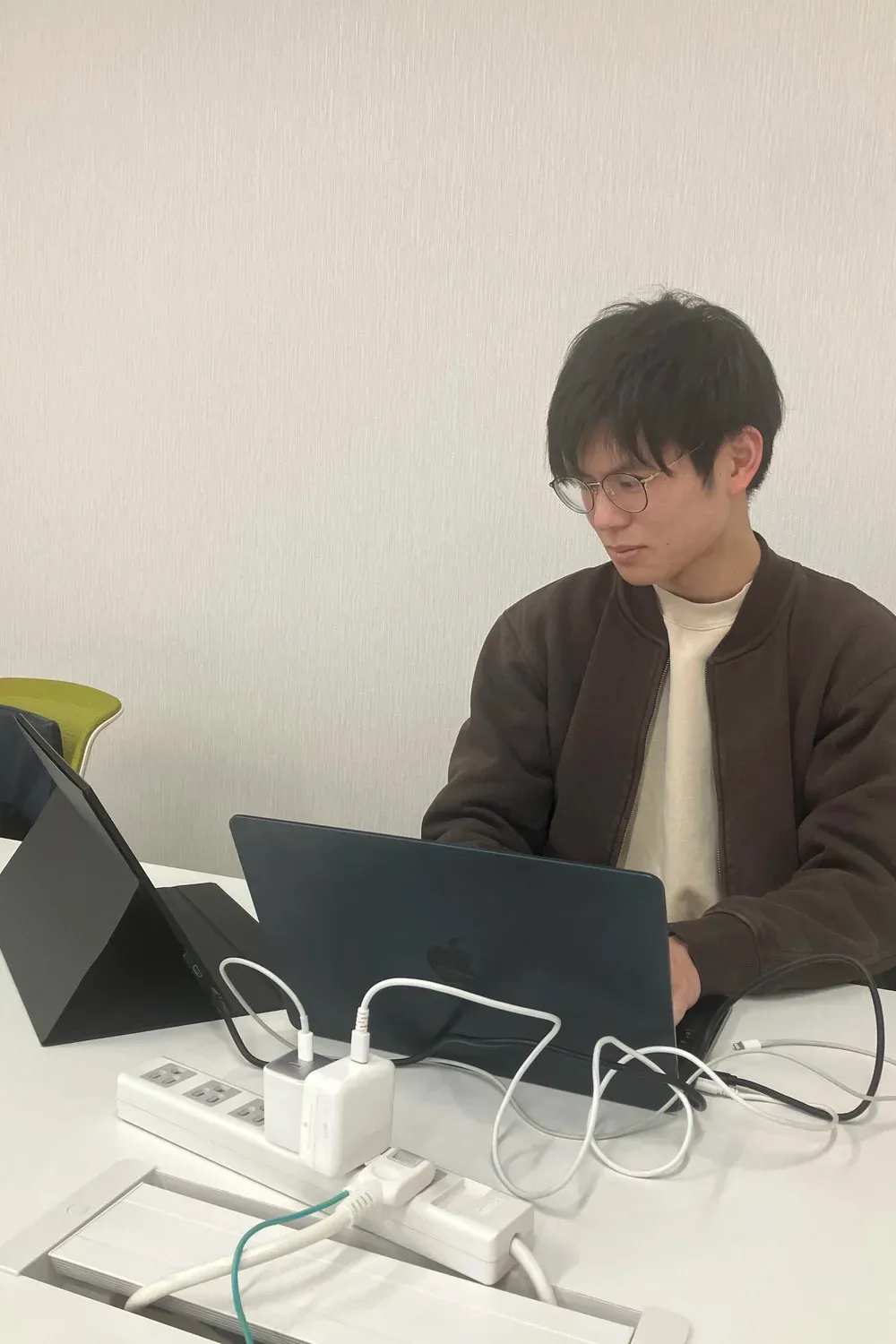 ノートパソコンで作業する沖野匠吾