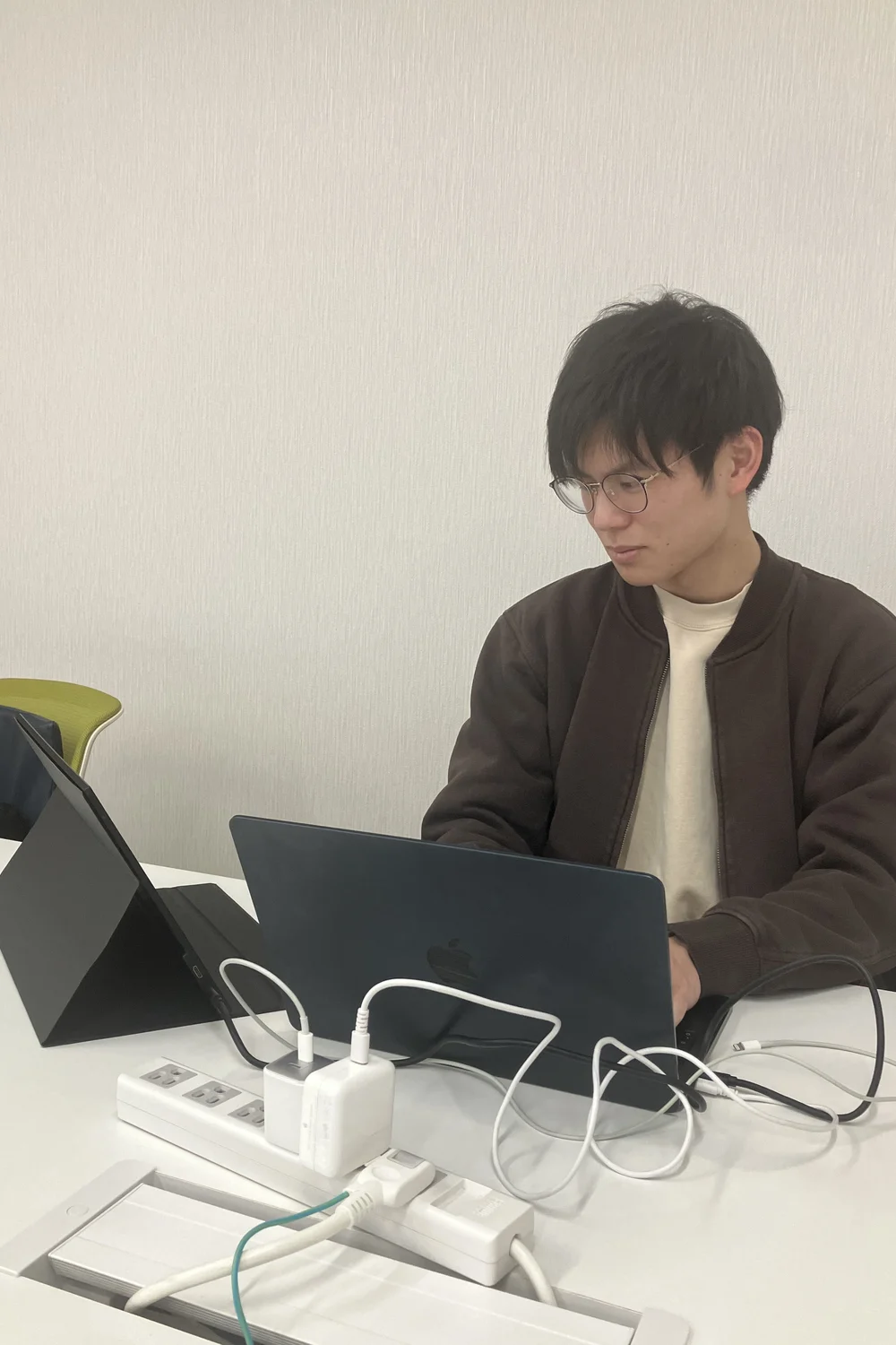 ノートパソコンで作業する沖野匠吾